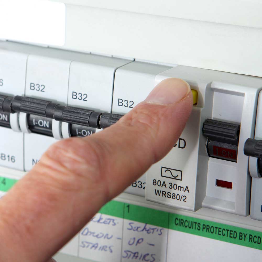 An electrician testing the RCD on a domestic consumer unit