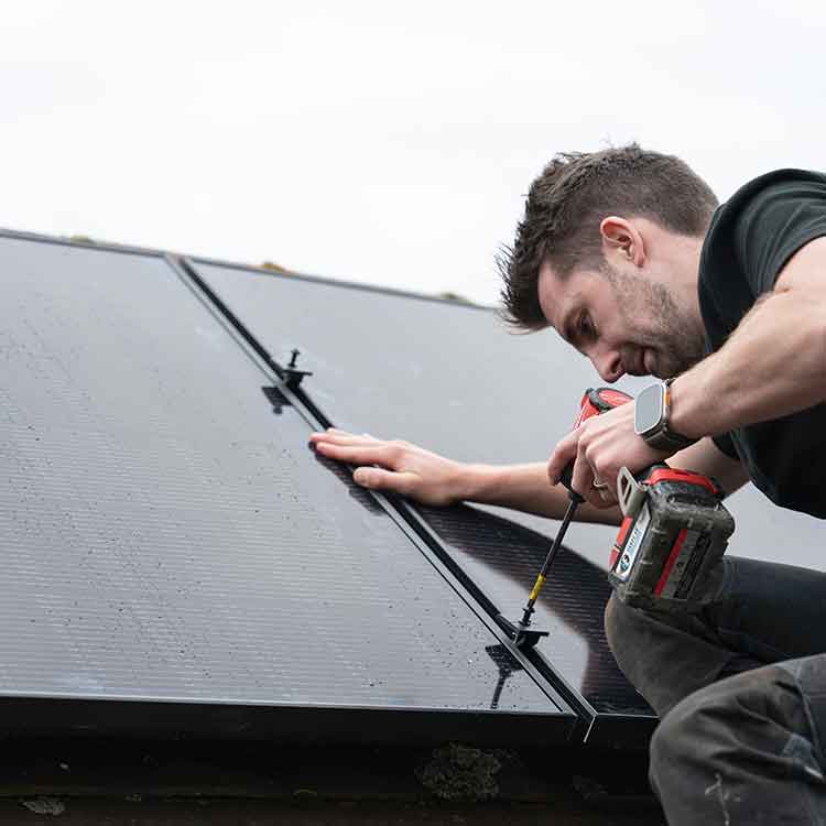 A skilled electrical engineer secures a solar pv panel to a rooftop