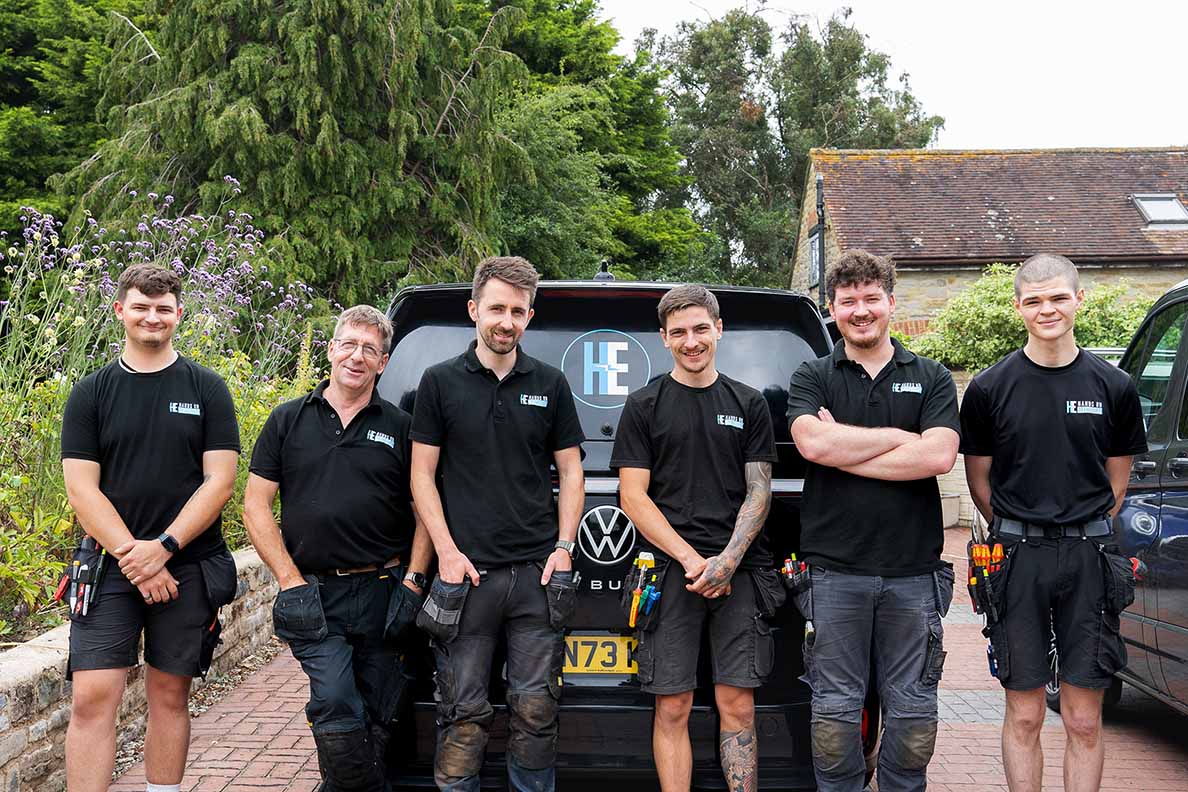 The Hands On Electrical team standing on a driveway with the company vehicle in the background