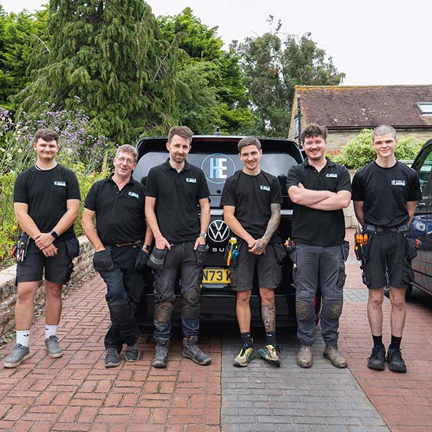 The Hands On Electrical team standing on a driveway with the company vehicle in the background