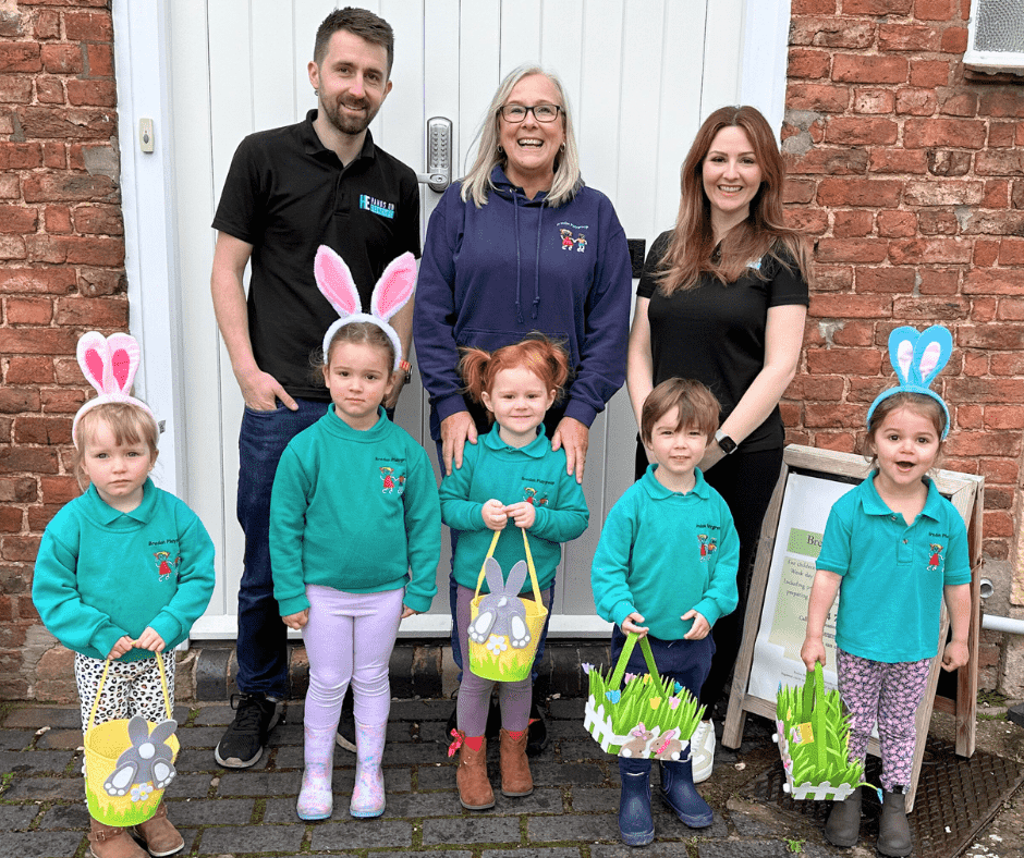 Hands On Electrical team members visiting Bredon Playgroup during a festive Easter celebration with children and staff.